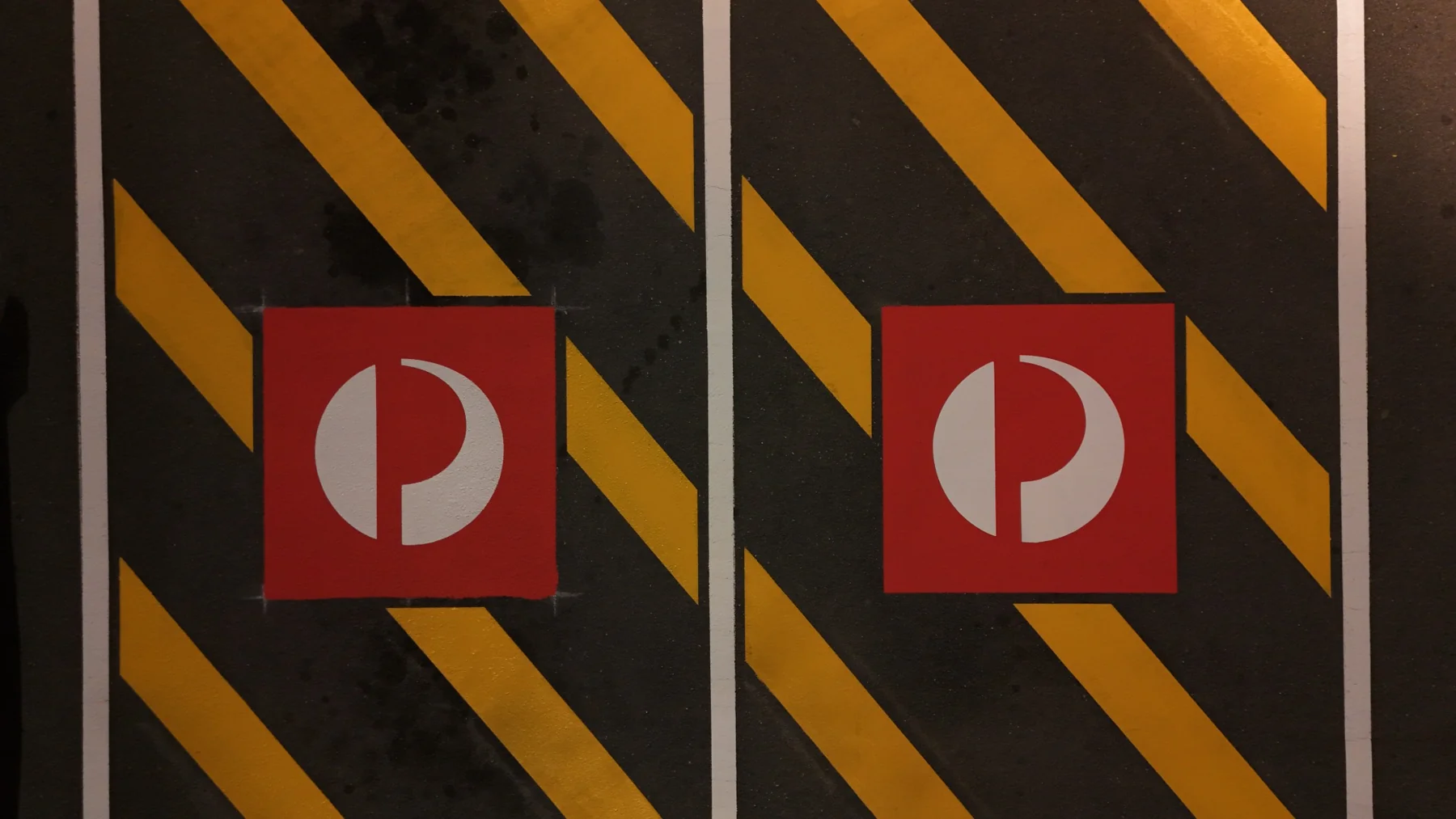 Overhead close-up of crisp yellow hatching and red Australia Post stencils