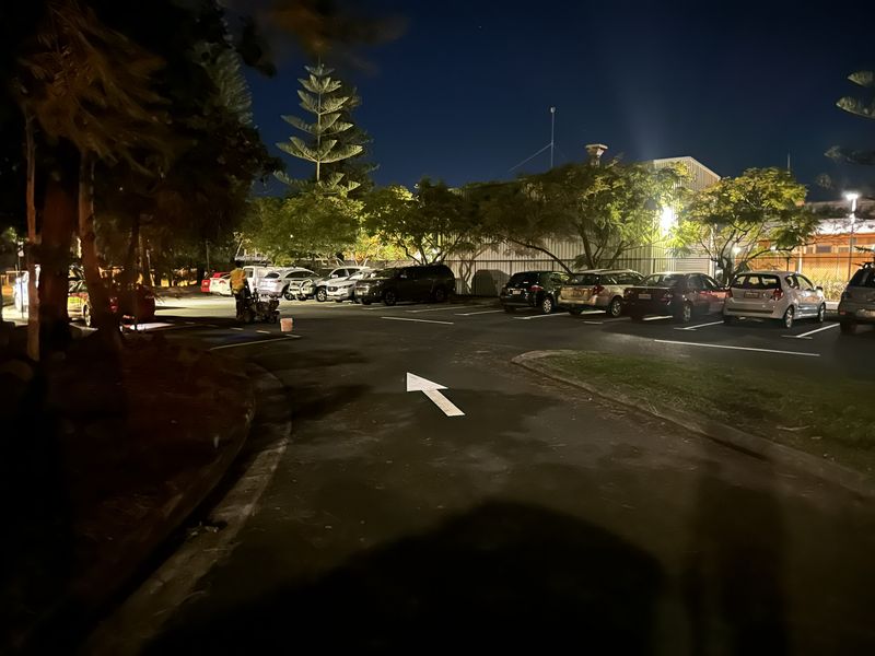 Line marking machine spraying fresh bay lines in a Redland Bay car park after dark