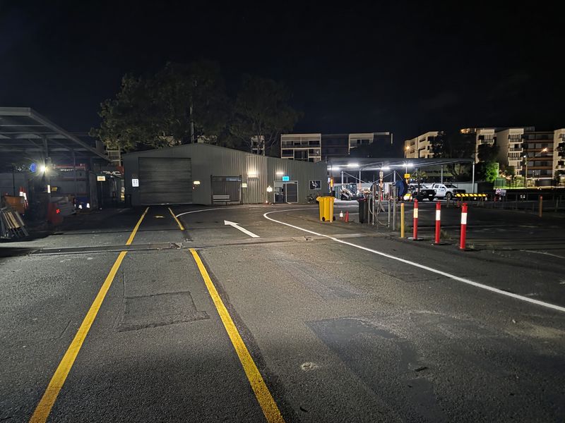 Double yellow centre lines, white edge line and a directional arrow through a depot yard on the Gold Coast