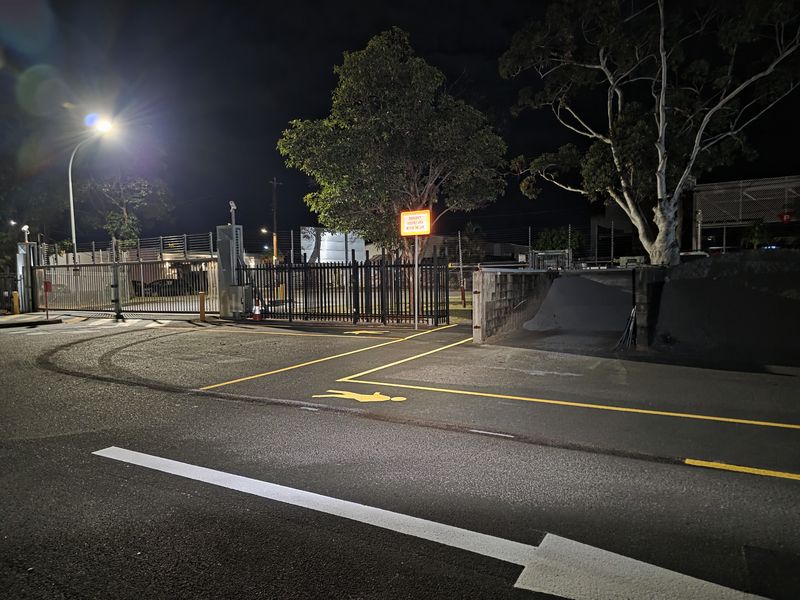 Yellow walkway and pedestrian symbol leading to an emergency assembly area gate on the Gold Coast