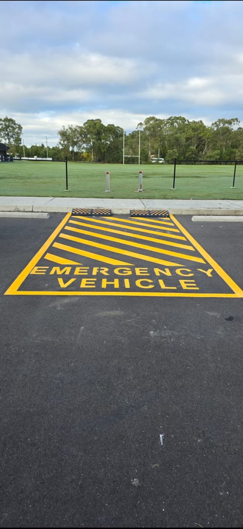 Yellow hatched emergency vehicle bay with wheel stops installed at the head of the bay on the Sunshine Coast
