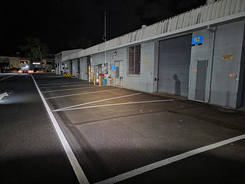 White parking bay outlines marked in front of warehouse roller doors at night on the Gold Coast