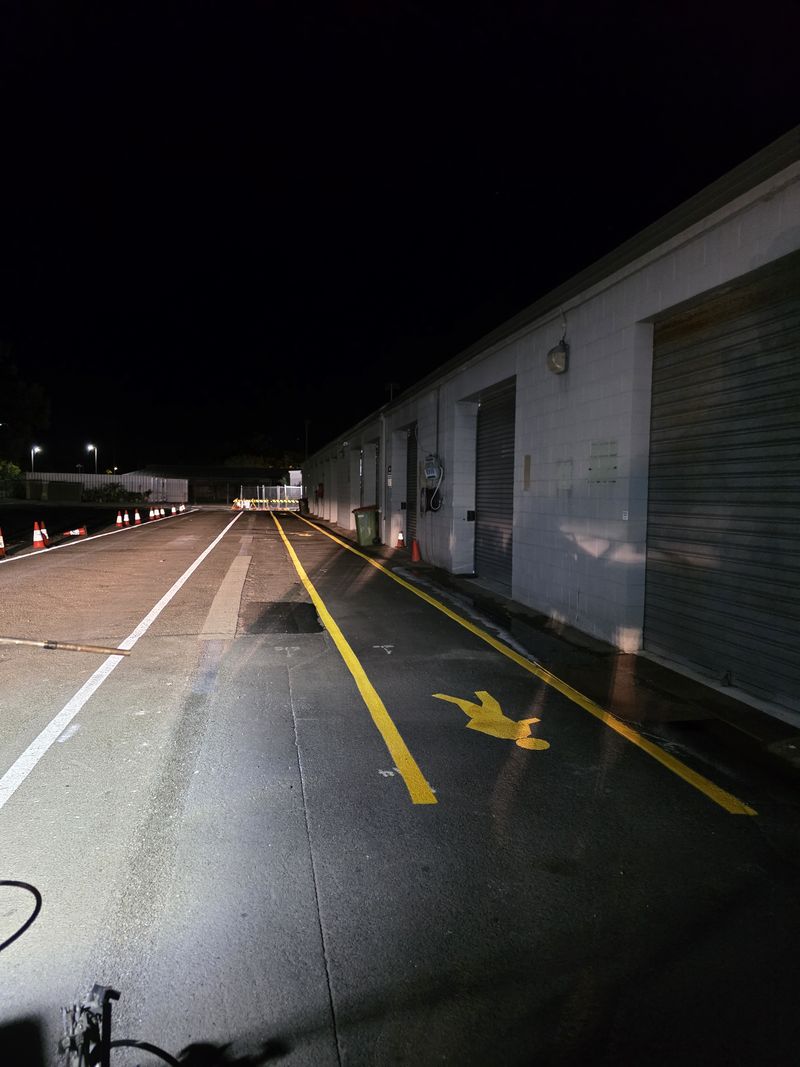 Yellow pedestrian walkway lines and pedestrian symbol alongside warehouse roller doors on the Gold Coast